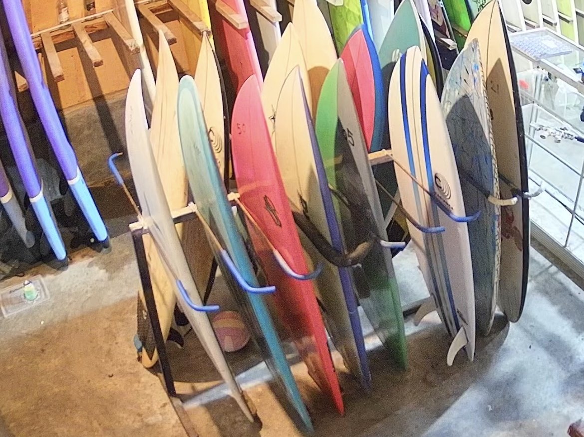 The rack inside the shop: fishes, shortboards and longboards standing side by side